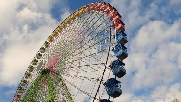 Colourful giant big wheel with blue cabins against a cloudy sky in Vigo